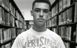 man in white crew neck t-shirt holding book