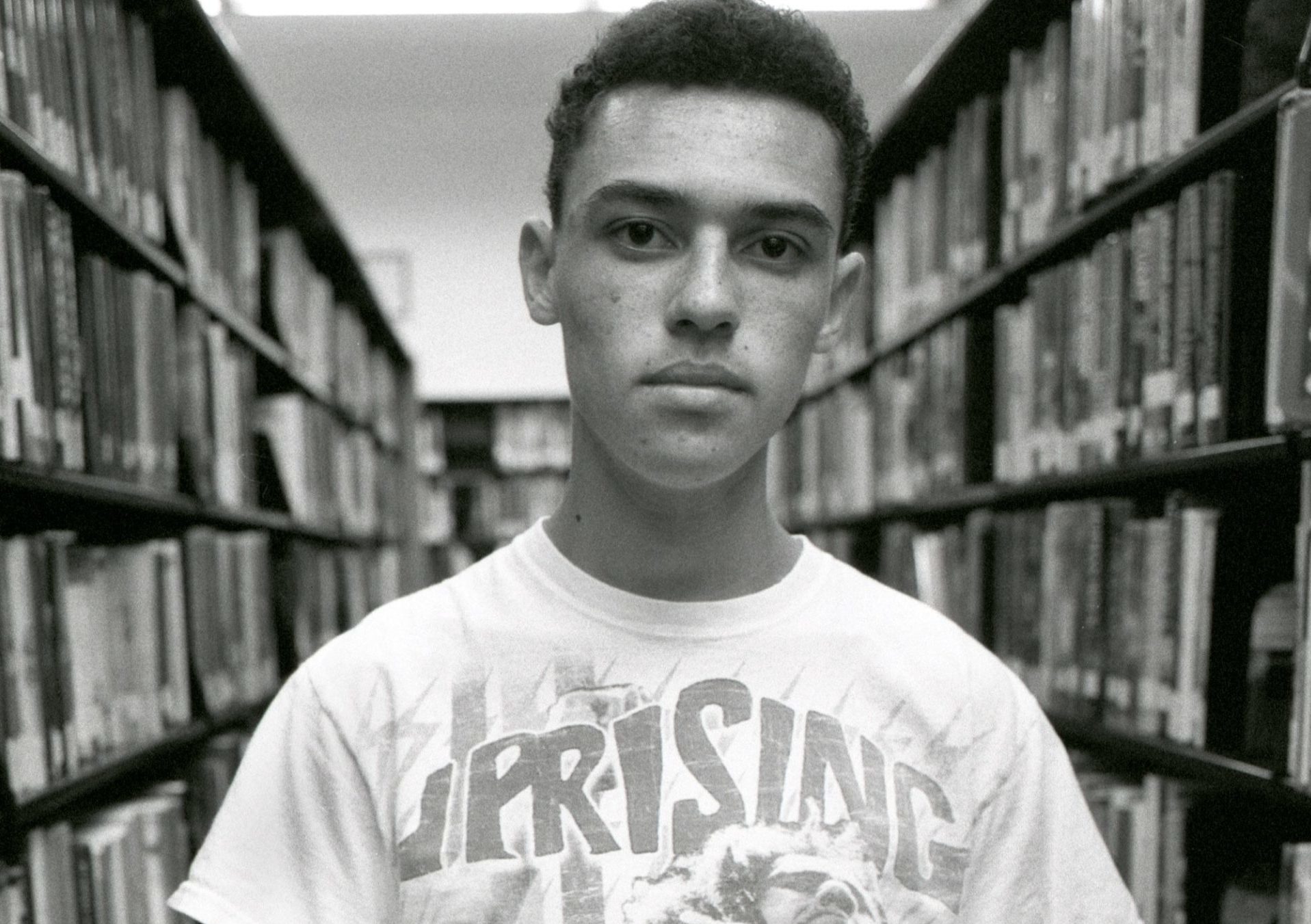 man in white crew neck t-shirt holding book